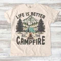 Mauve graphic t-shirt with "Campin' Vibes Only" outdoor design, styled in a flat lay with a flannel plaid shirt and camera on a wooden surface