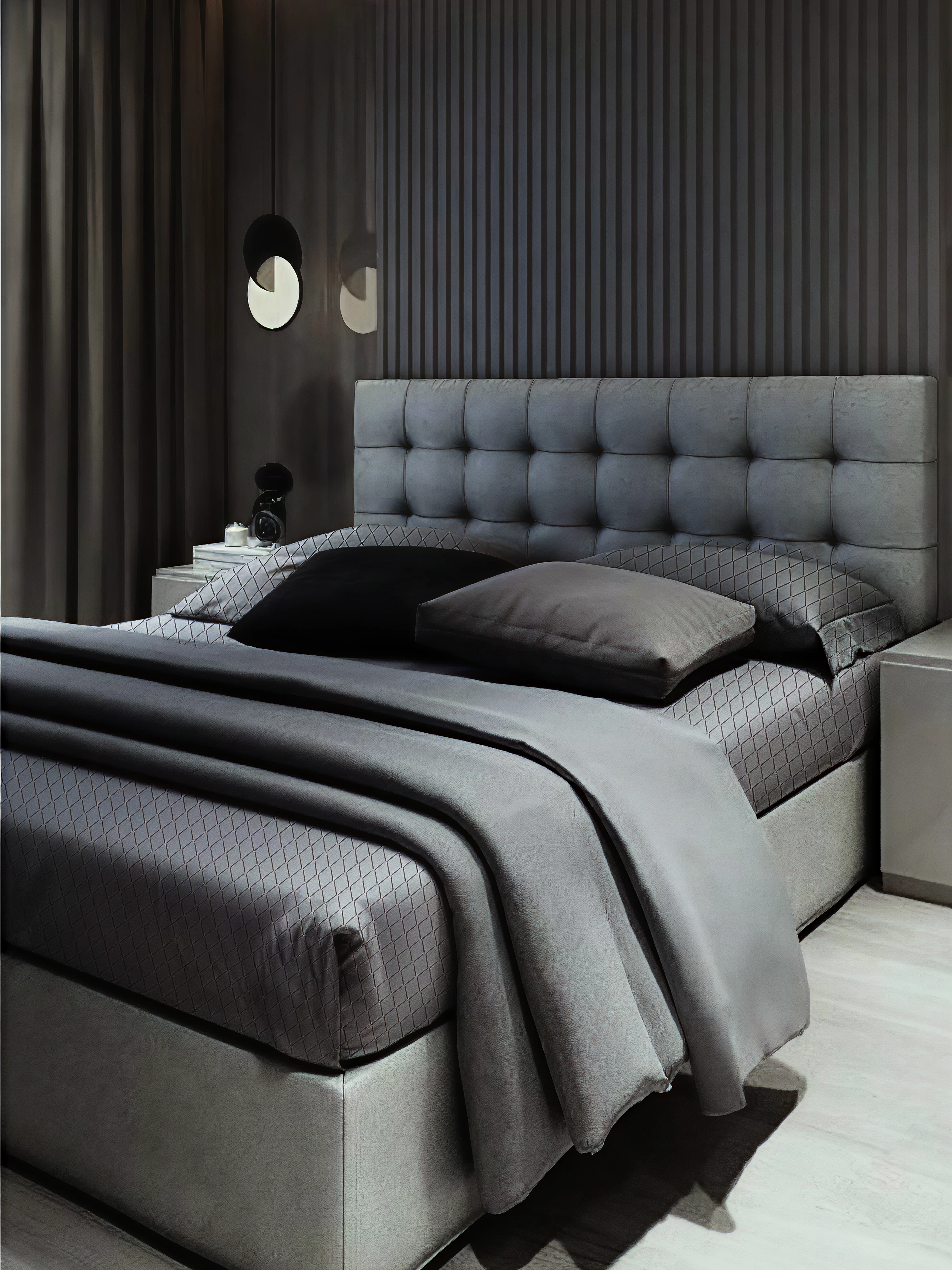 Modern bedroom with a gray upholstered bed and matching bedding.