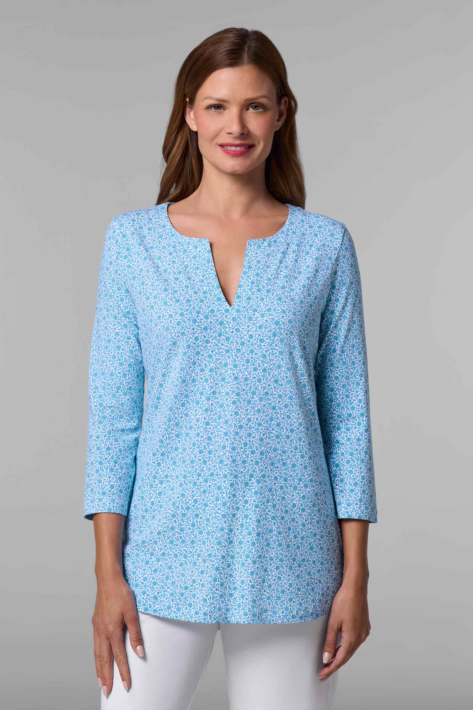 Woman wearing a light blue floral blouse against a gray background