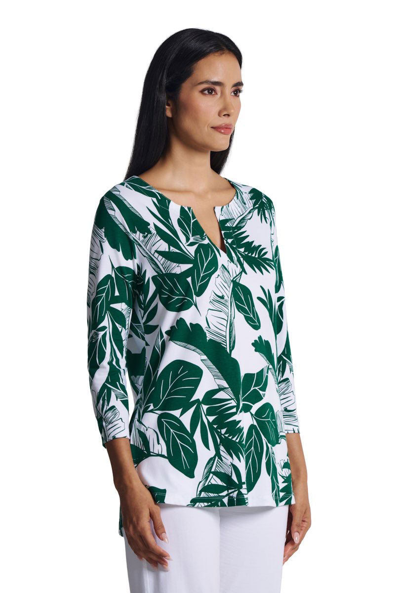 Woman wearing a green and white leaf-patterned blouse on a white background