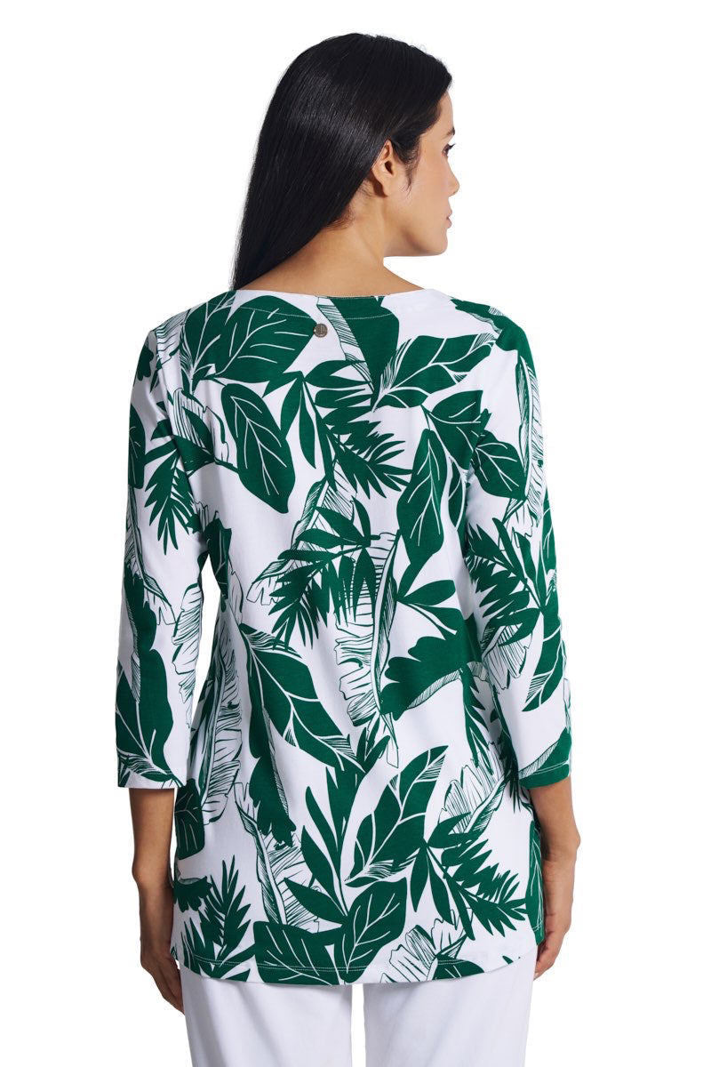 Woman wearing a green and white leaf-patterned shirt on a white background