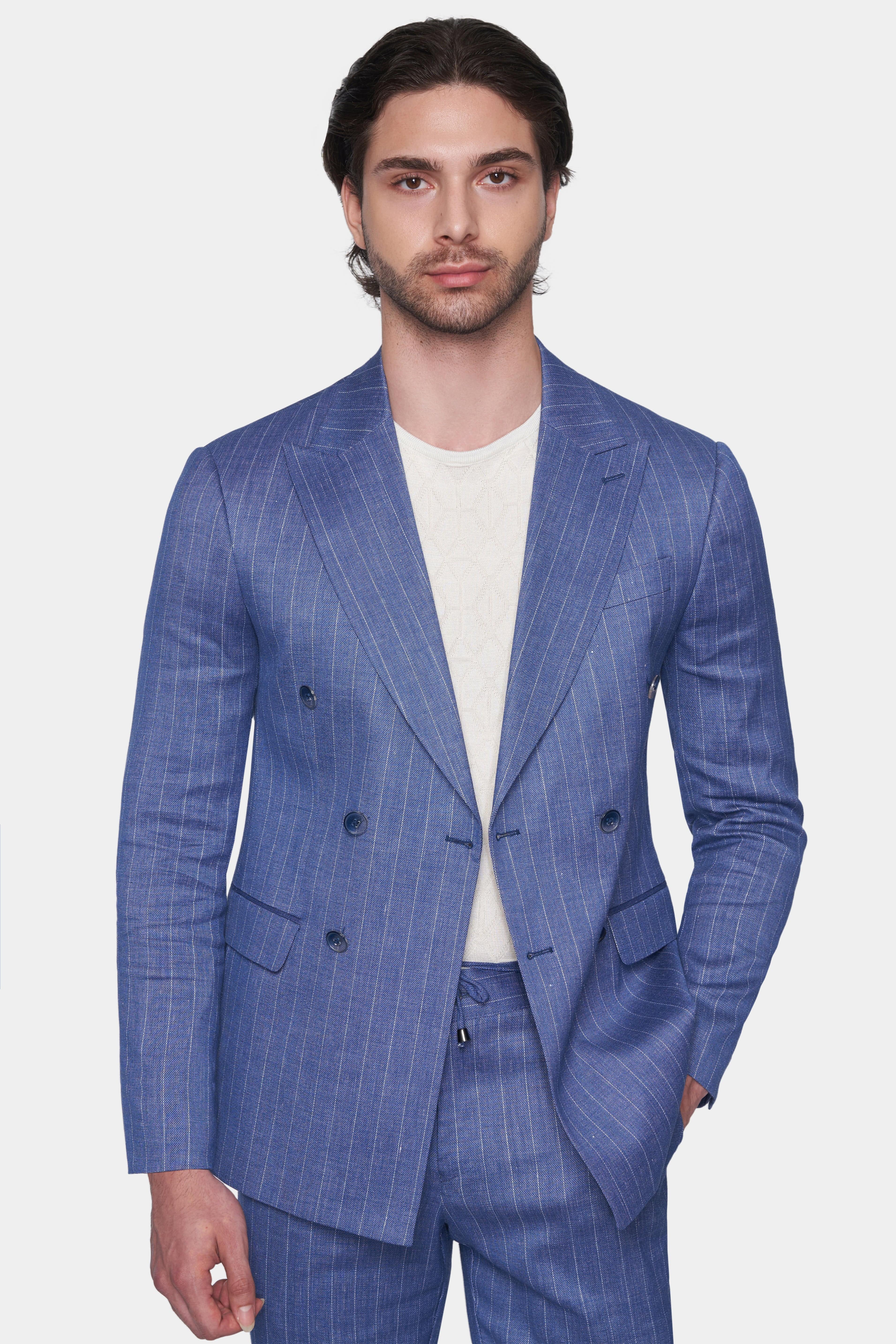 Man wearing a blue checkered suit with a white shirt on a light gray background