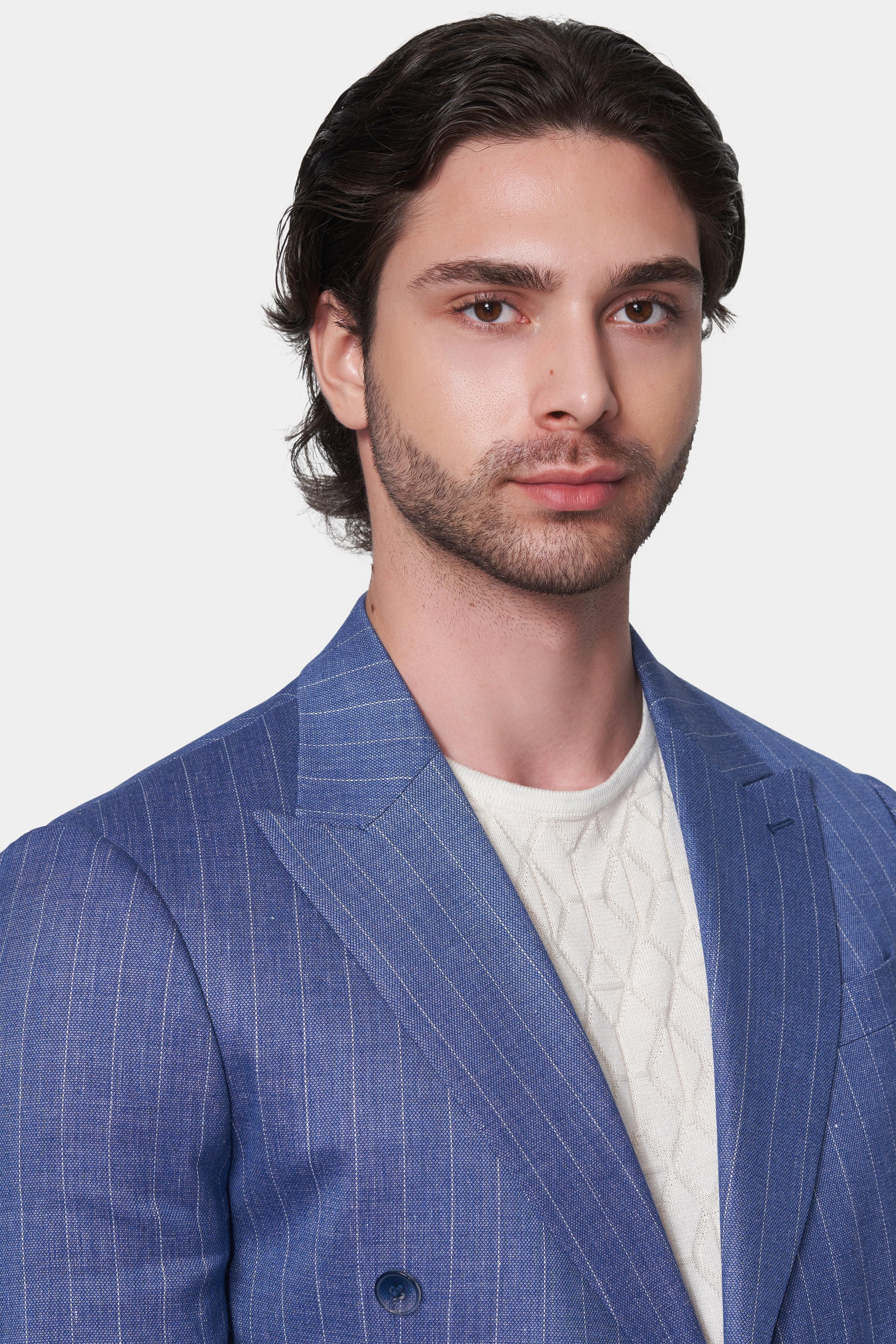 Man wearing a blue pinstripe suit with a white shirt on a light gray background