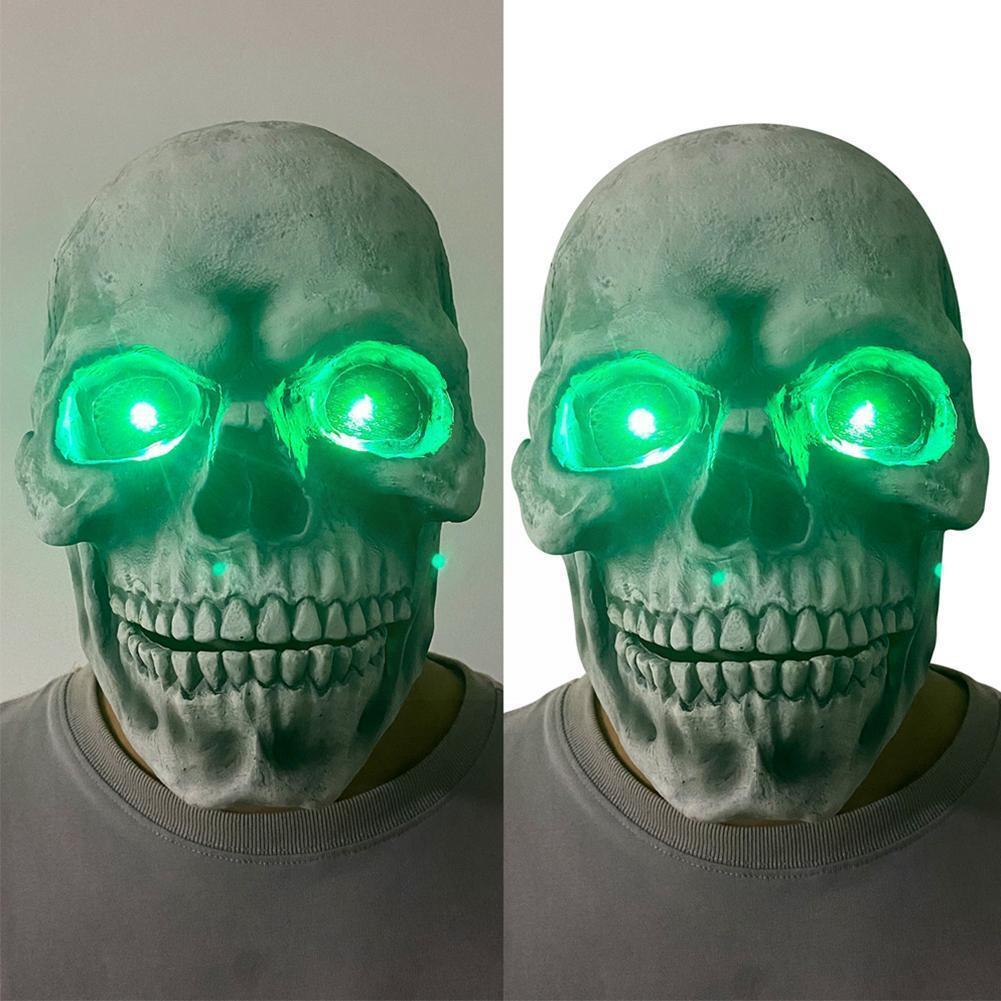Skull mask with glowing green eyes on a person against a neutral background