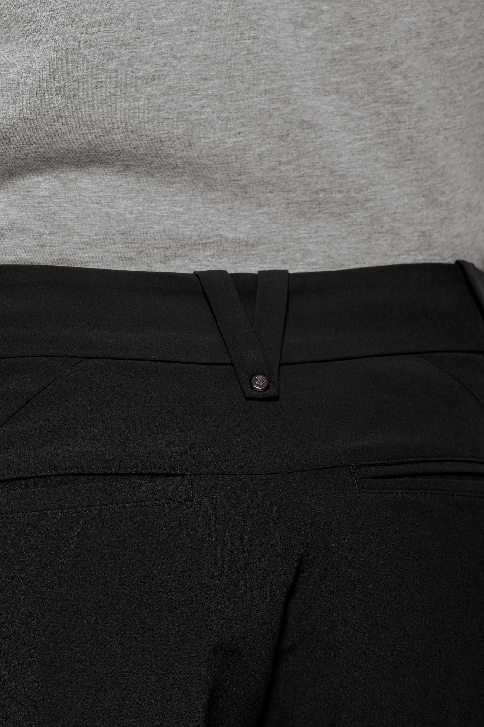 Close-up of black pants with a gray shirt in the background
