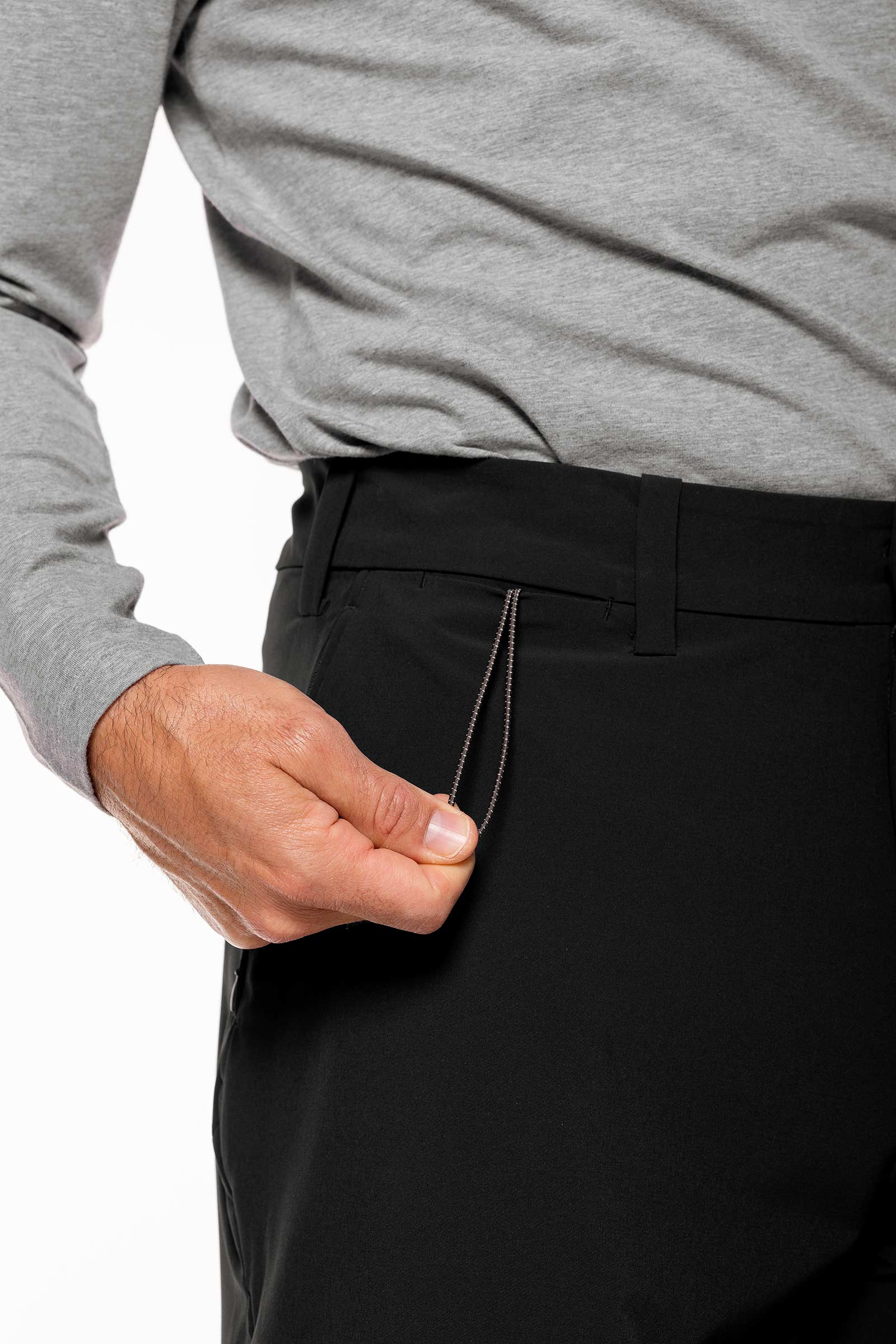 Person wearing a gray shirt and black pants with a white background