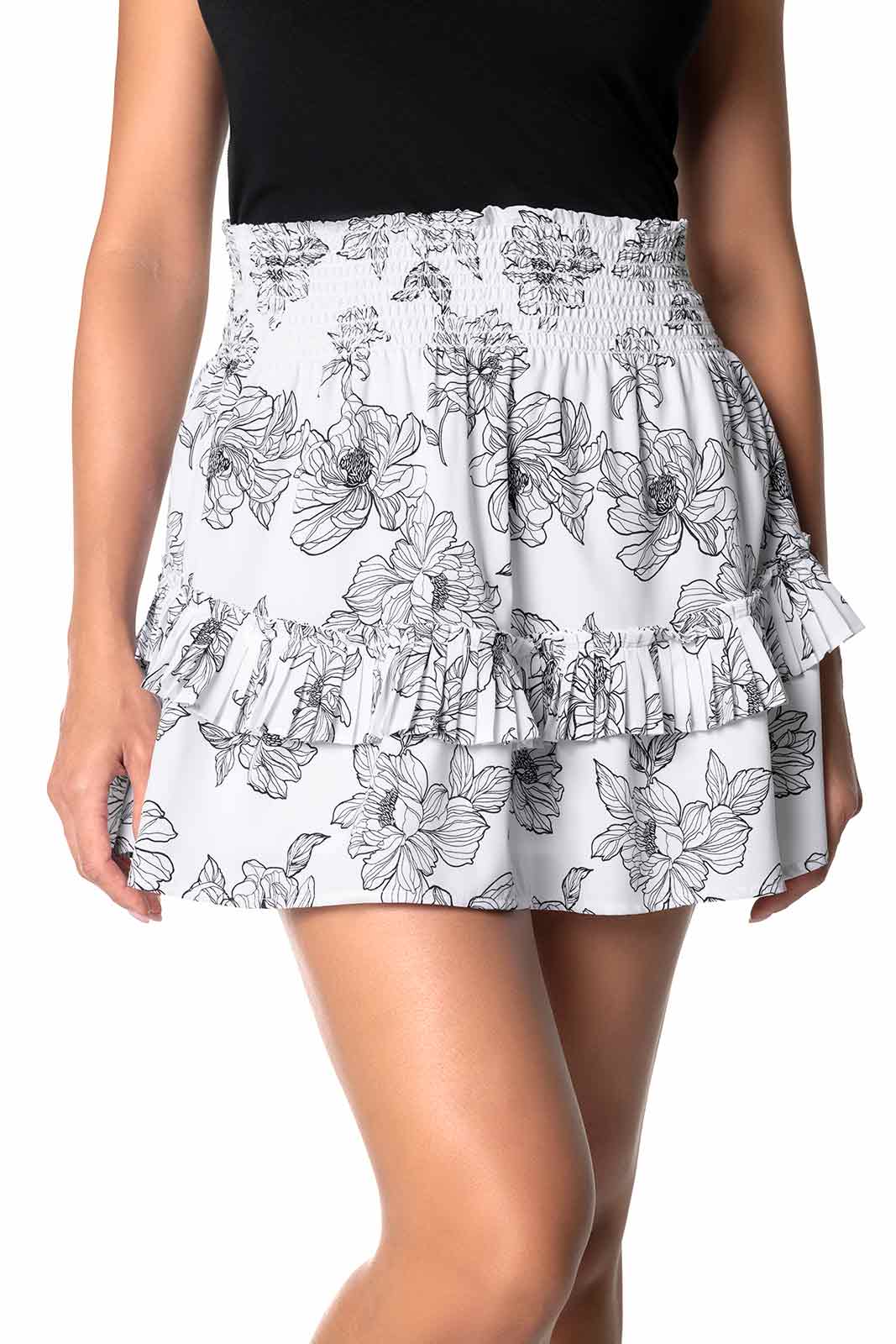 White skirt with black floral pattern worn by a person on a white background