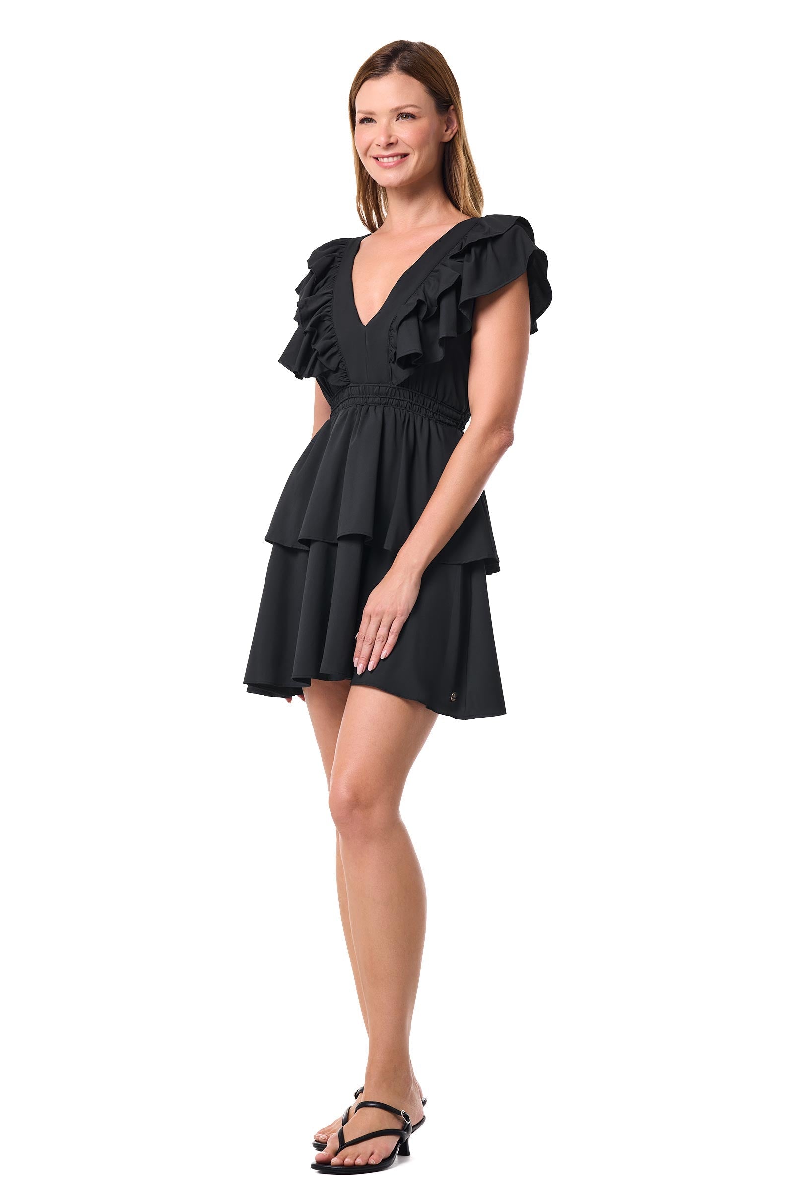 Woman wearing a black dress with ruffled sleeves on a white background