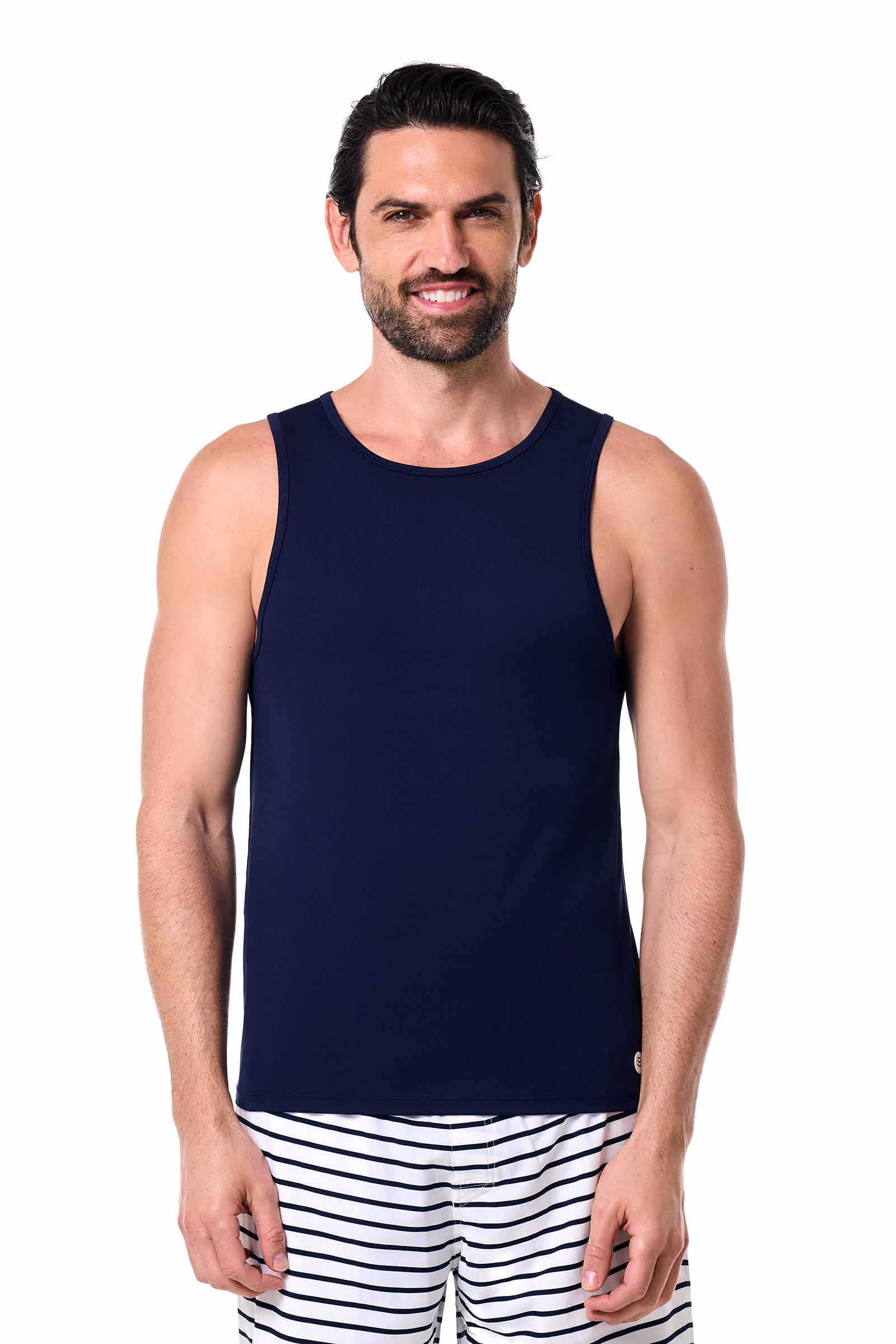 Man wearing a navy tank top and striped pants on a white background