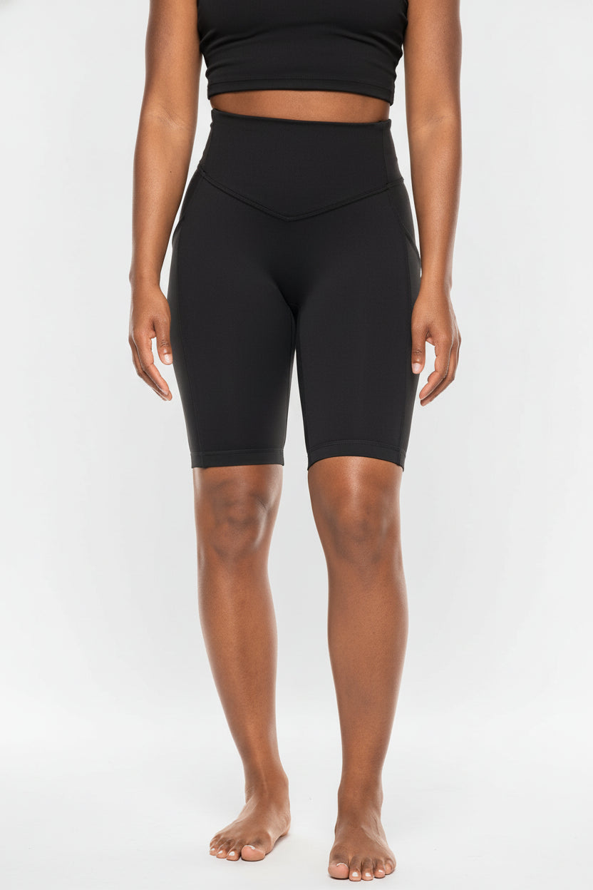 Person wearing black high-waisted shorts on a white background