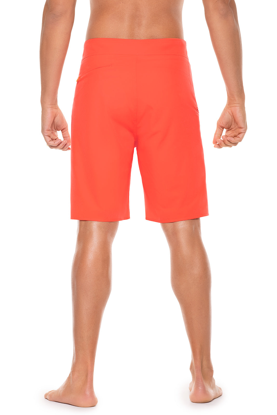 Person wearing bright orange shorts on a white background