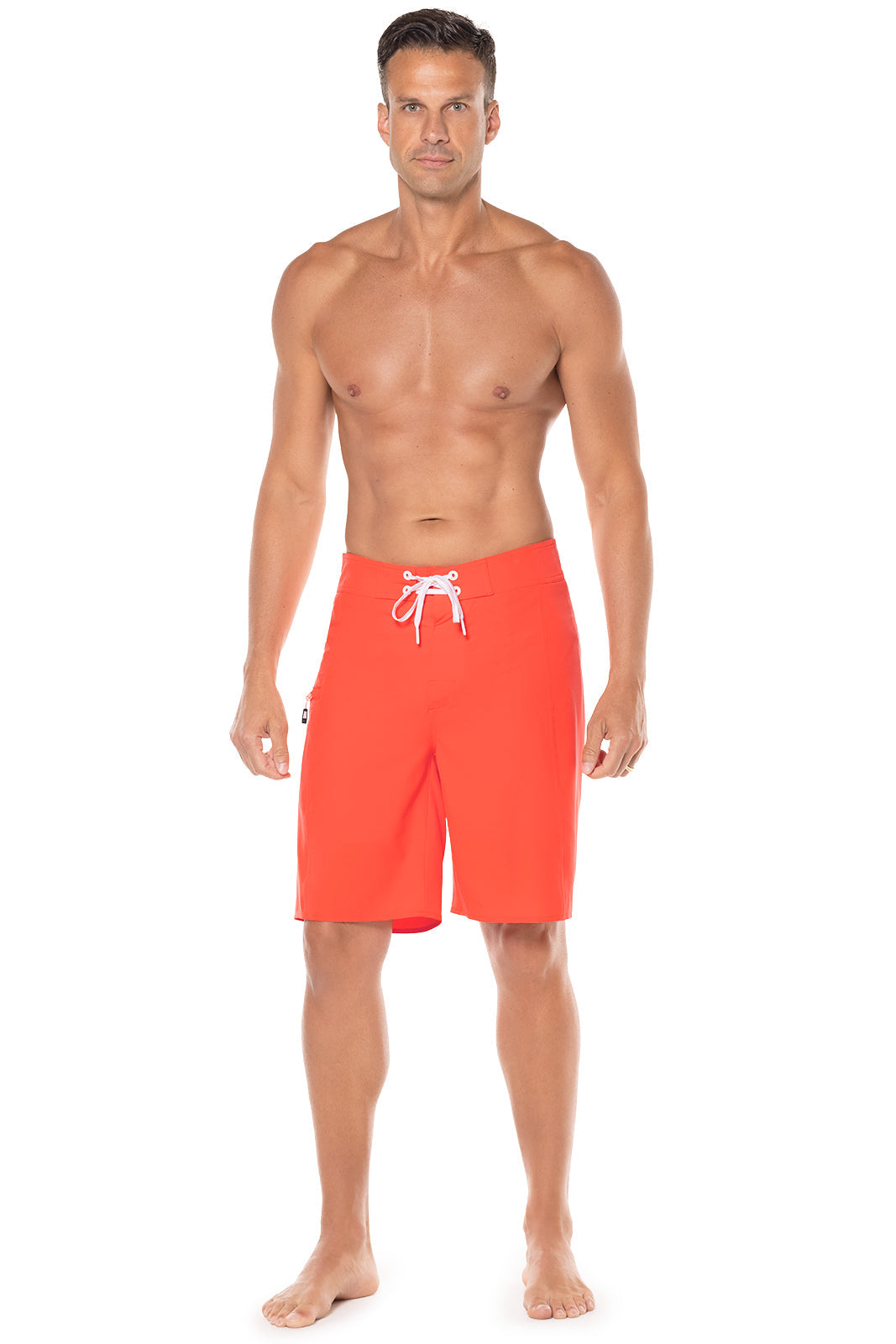 Man wearing bright orange swim shorts with a white drawstring on a white background