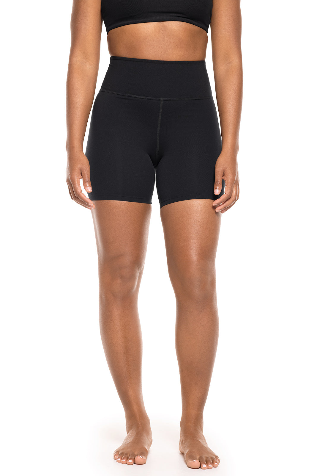 Person wearing black athletic shorts on a white background