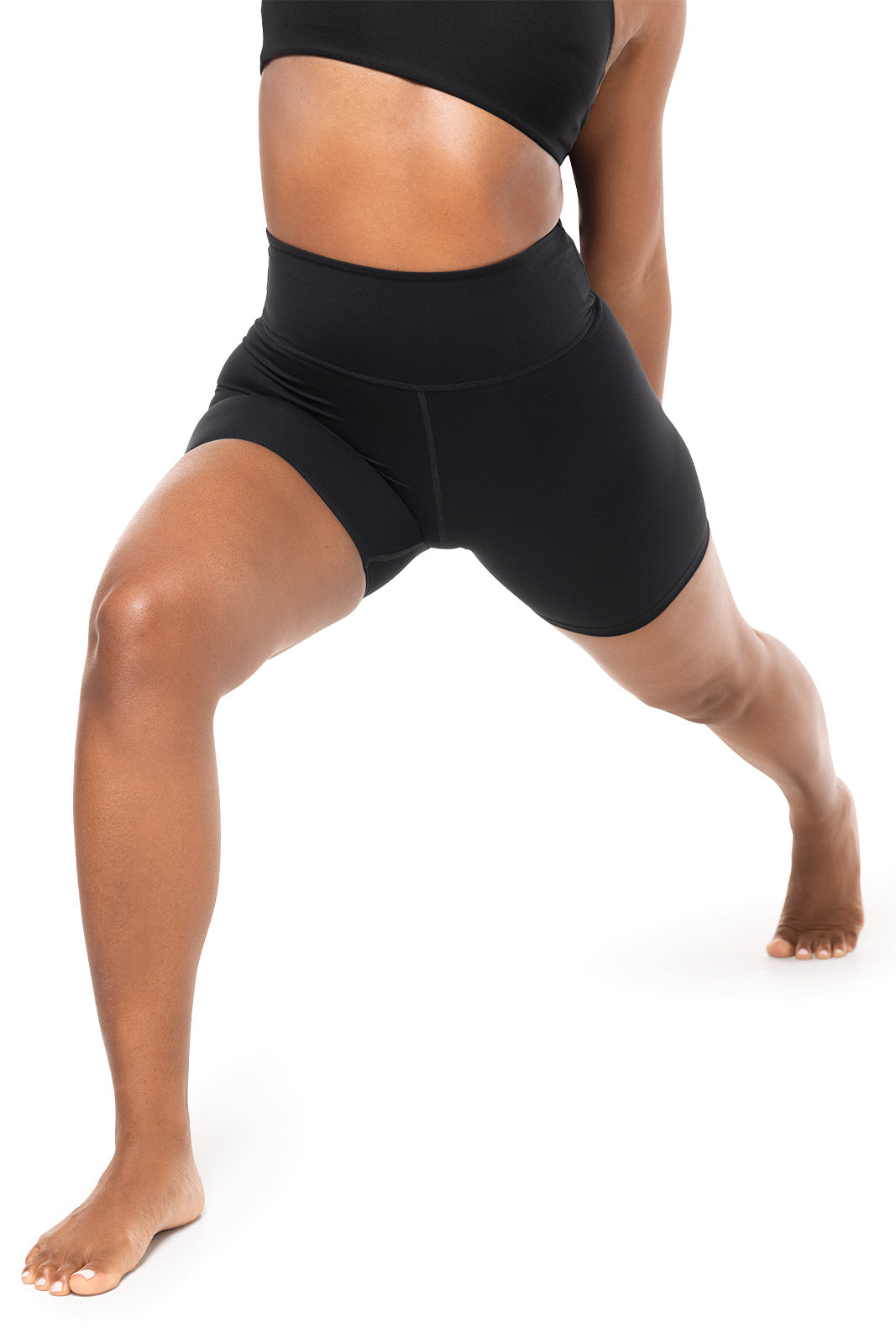 Person wearing black athletic shorts on a white background
