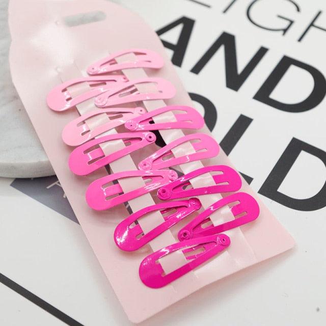 Set of pink hair clips on a pink card with text in the background