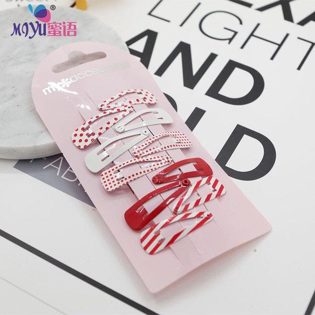 Set of hair clips on a pink card with 'MIYU' branding, on a magazine background.