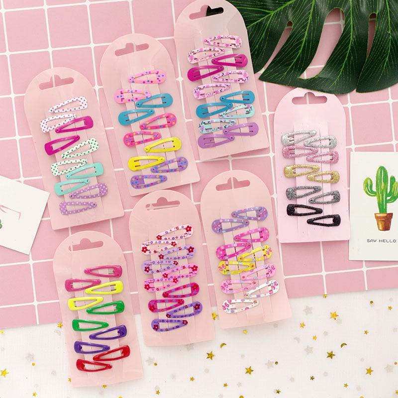 Colorful hair clips on pink cards with a cactus plant in the background