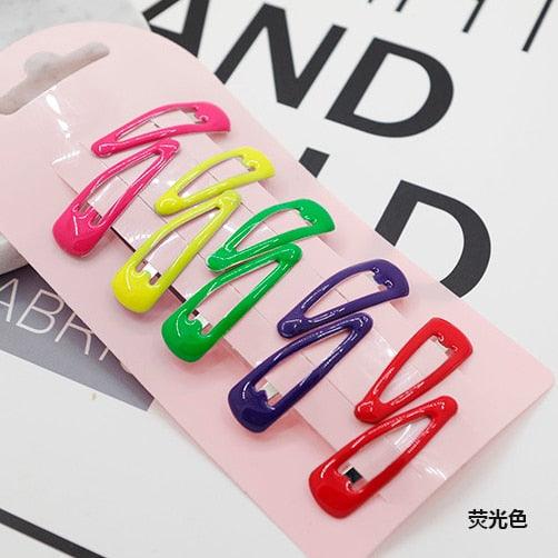 Set of colorful hair clips on a pink card with visible brand name.