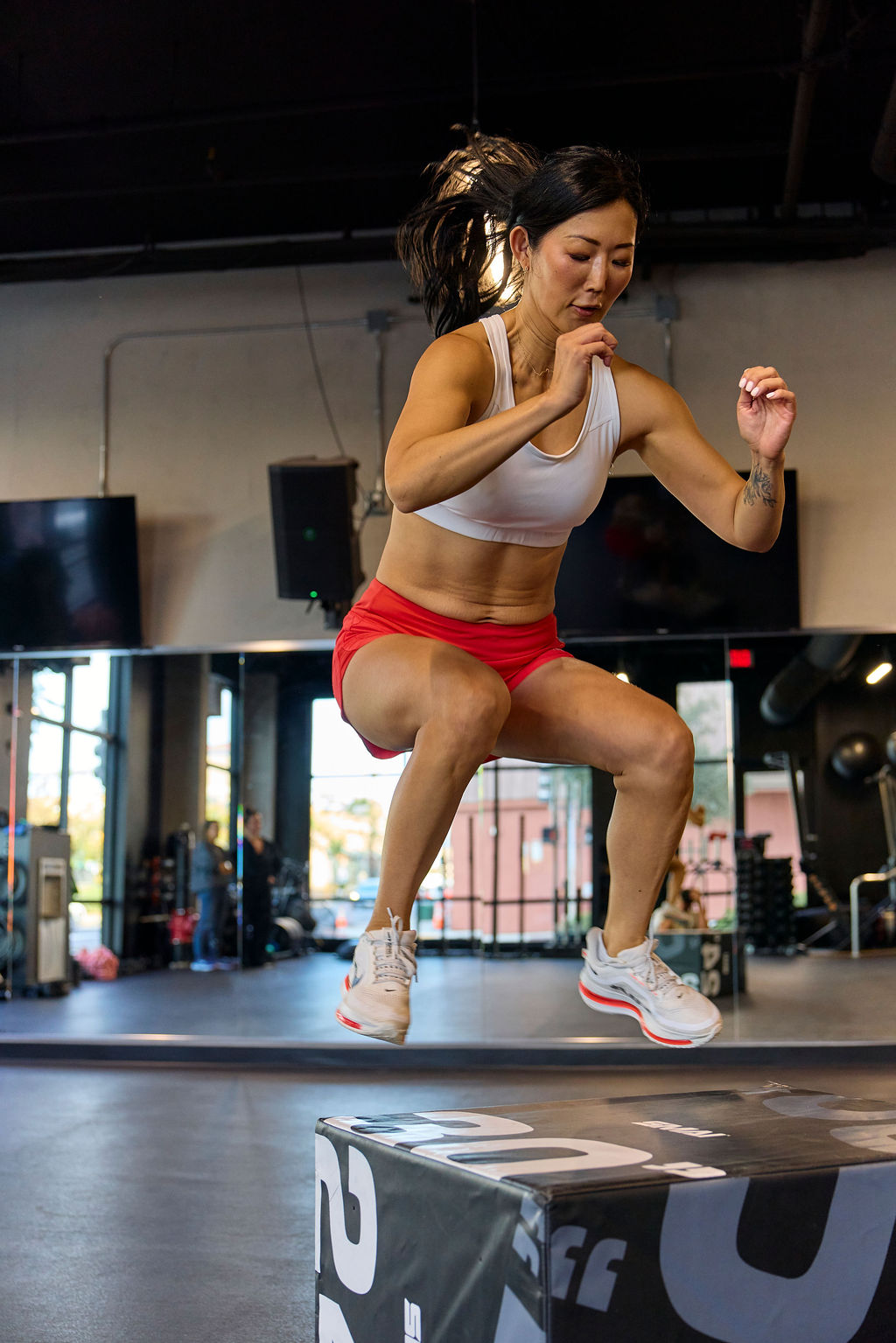 Woman performing box jumps in a gym setting