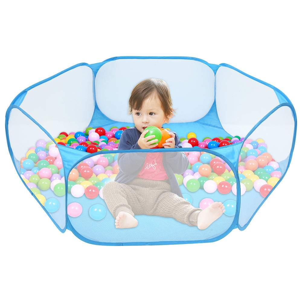 Child playing with colorful balls inside a blue ball pit on a white background