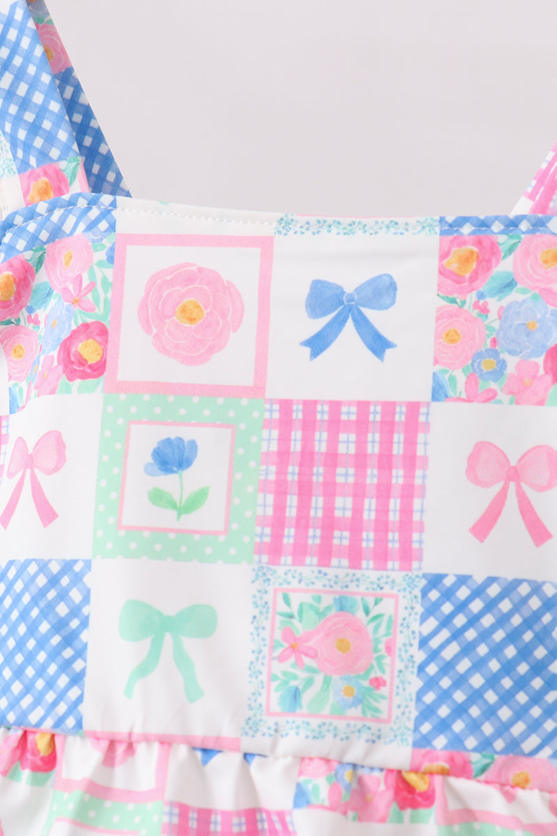 Patchwork quilt with floral and bow patterns on a light background