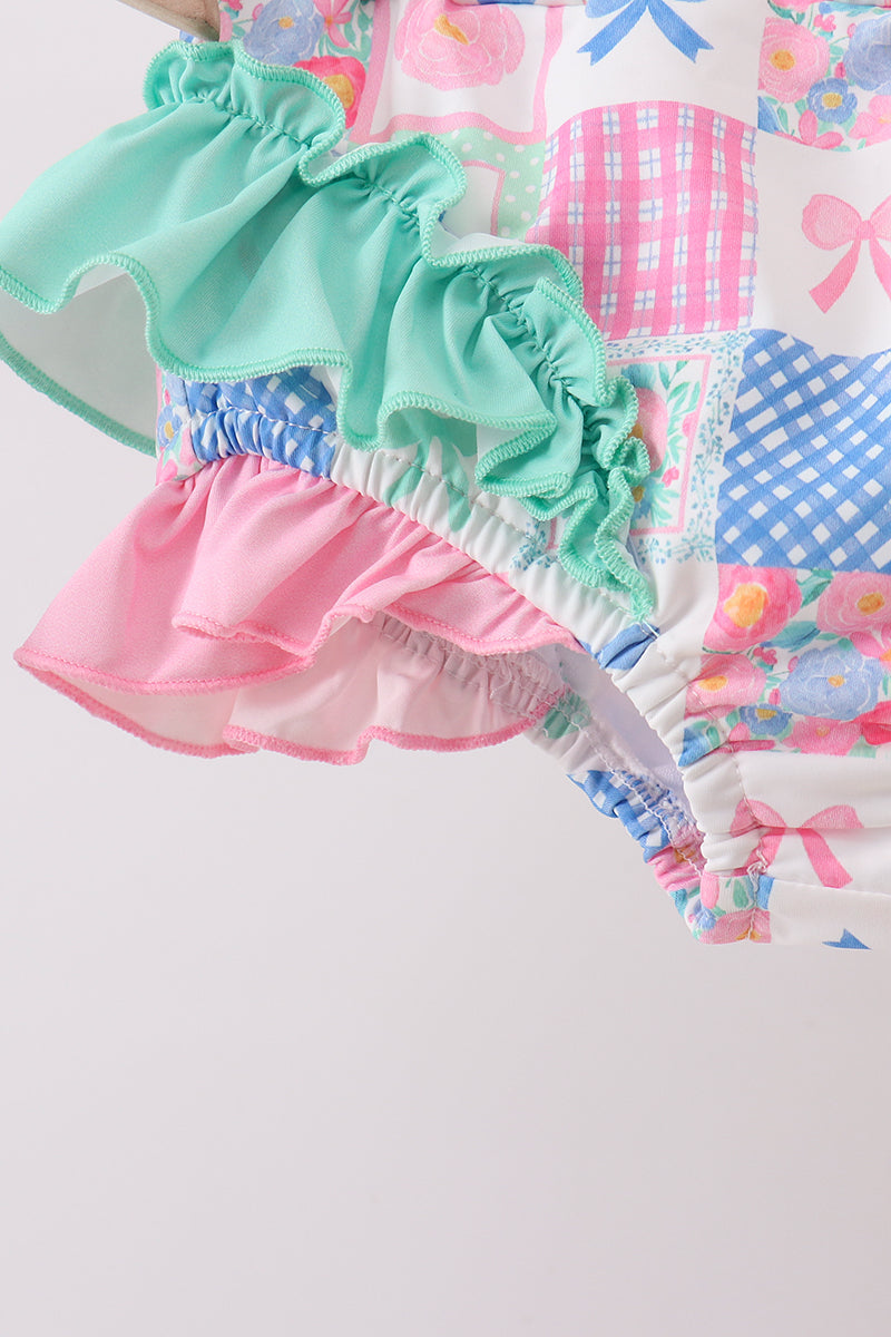 Colorful children's outfit with ruffled layers on a patchwork background