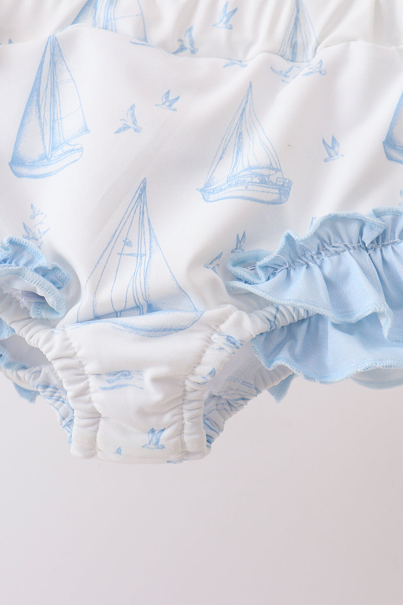 White bloomers with a light blue sailboat and bird pattern, featuring a ruffled elastic waistband and leg openings.