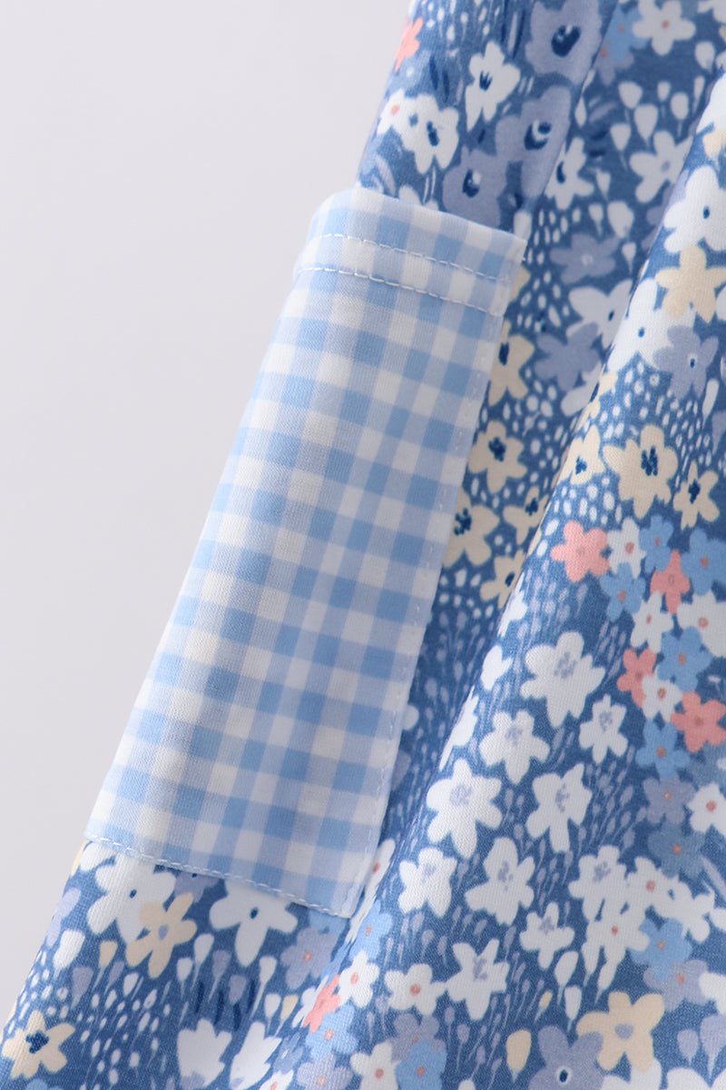 Close-up of a blue floral fabric with a contrasting light blue and white gingham pocket lining.