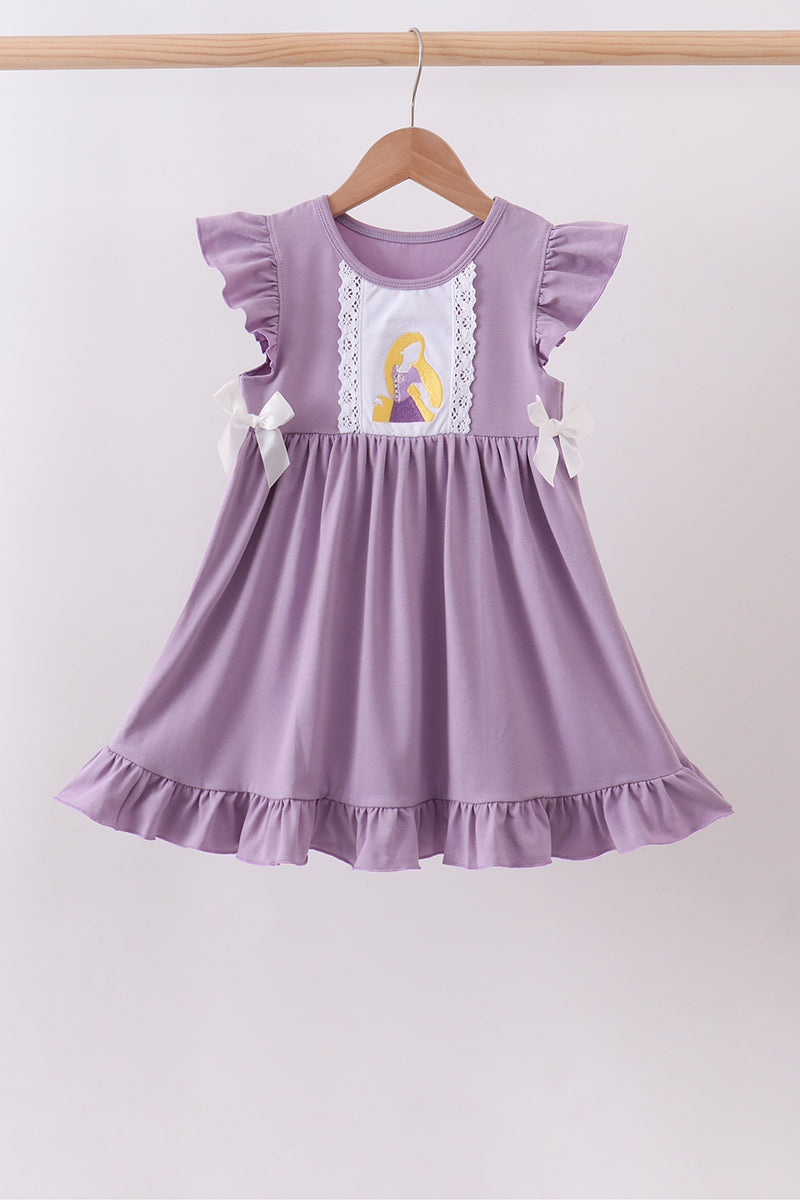A lavender purple baby girl's dress with ruffled cap sleeves, a white lace panel, and a graphic of Rapunzel on the chest, hanging on a wooden hanger against a light gray background.