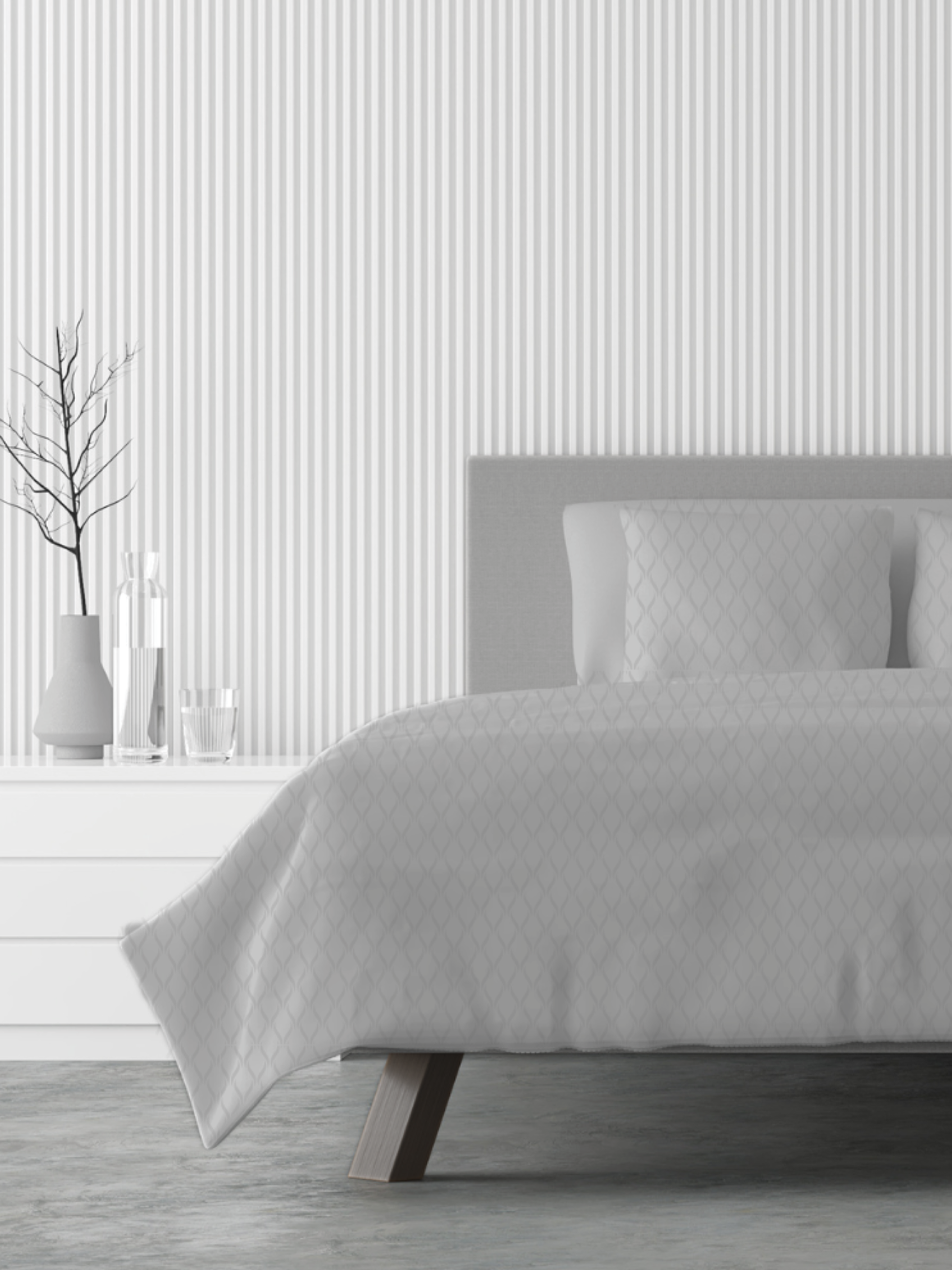 Gray quilted cover on a bed with a minimalistic room design.