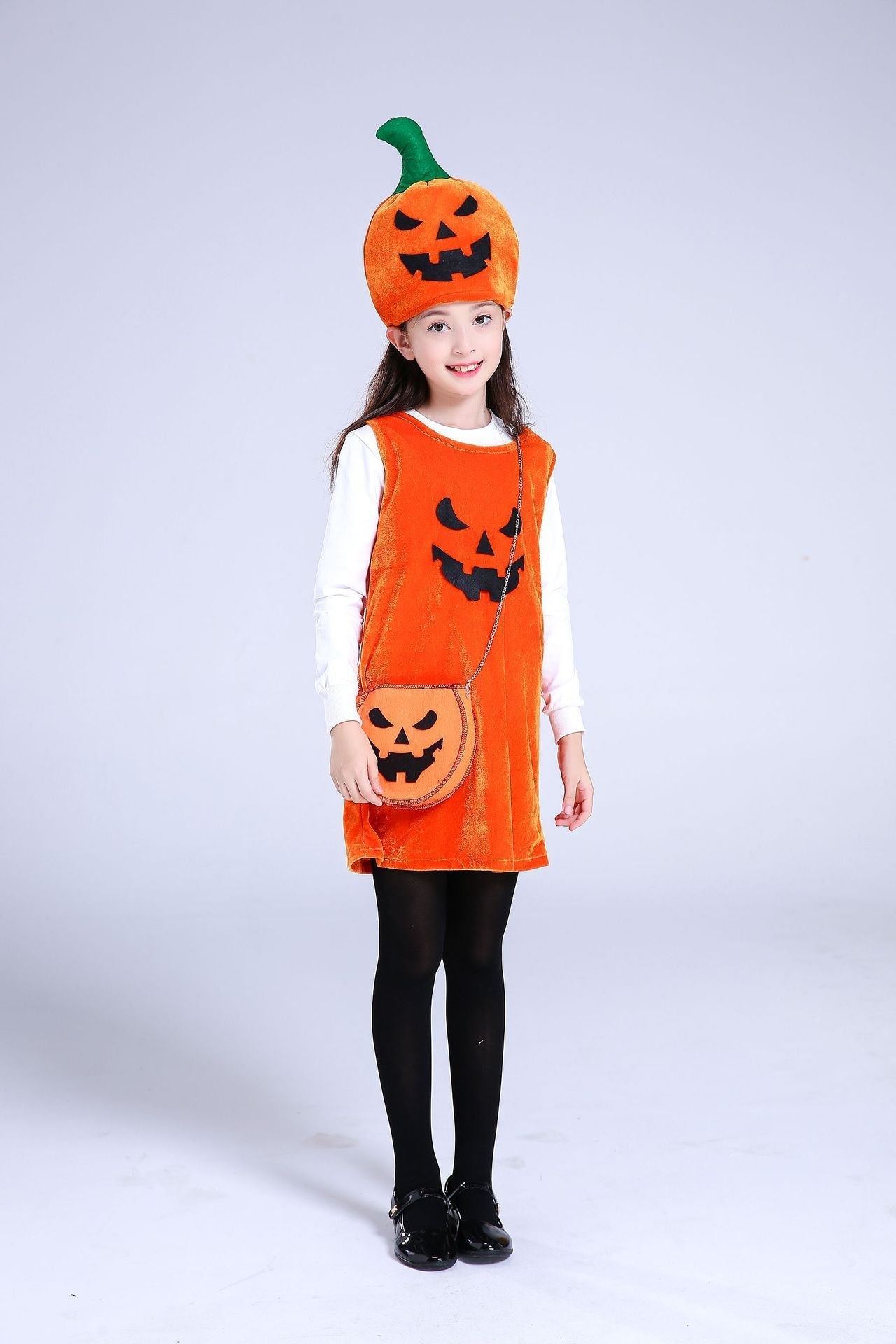 Child wearing an orange pumpkin-themed costume with a hat and bag on a white background