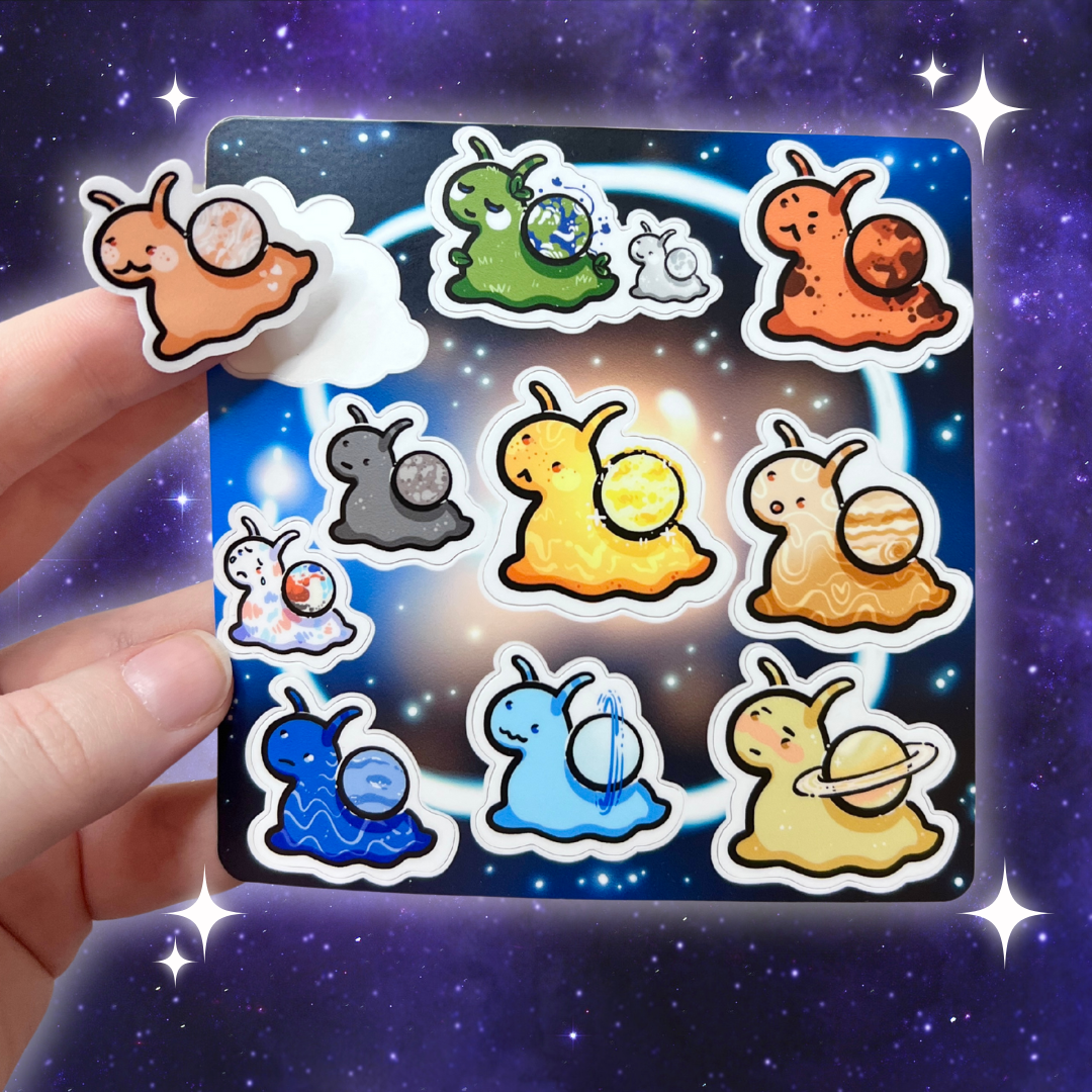 Set of colorful snail-shaped stickers on a space-themed card held by a hand against a starry space background.