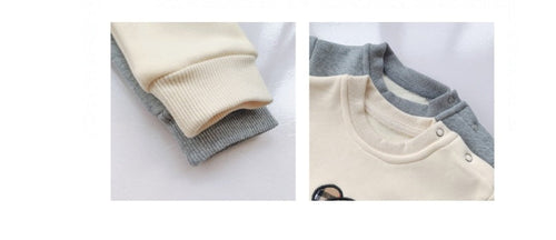 Two pairs of baby pants, one beige and gray, the other gray and white, on a white background.