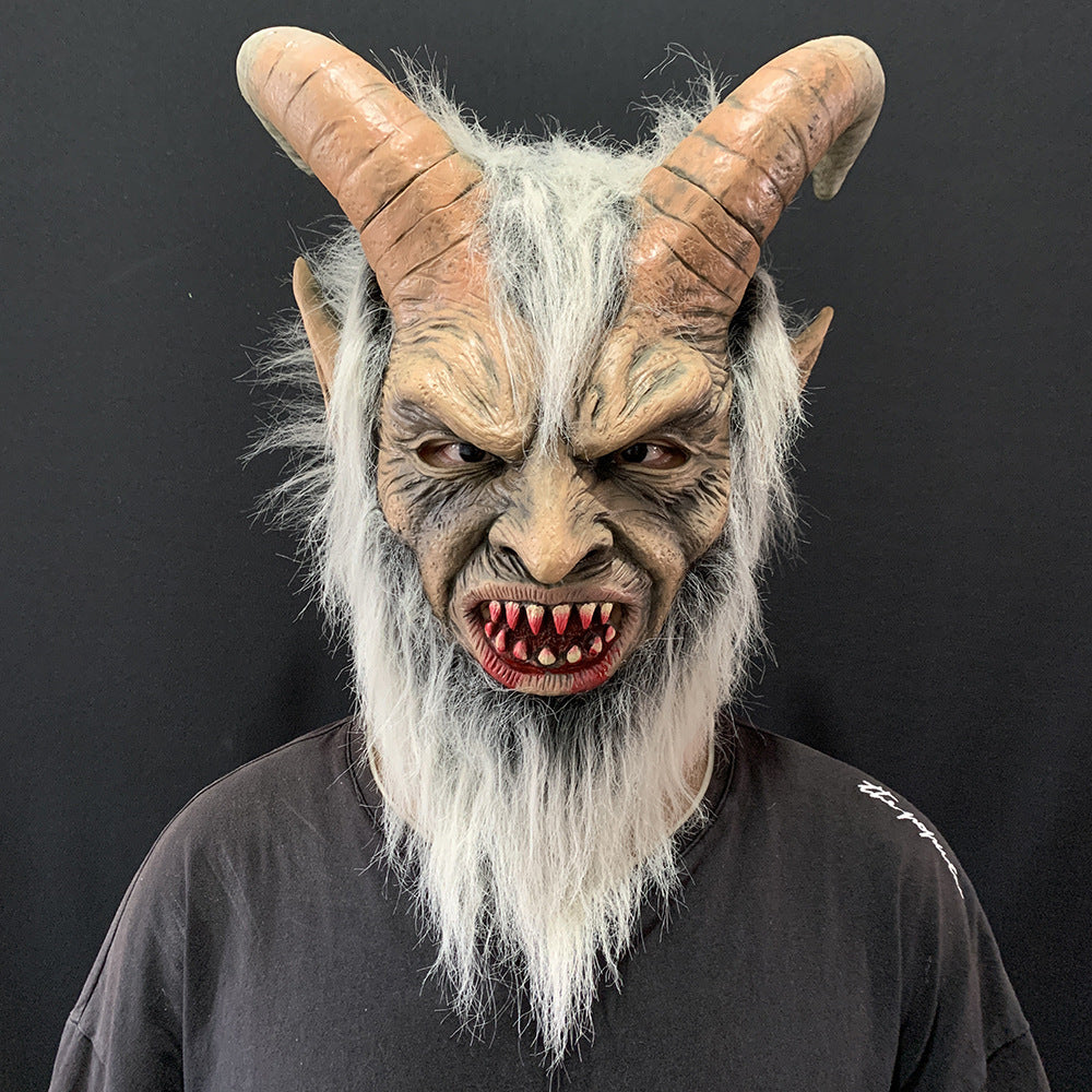 A person wearing a detailed horned demon mask with long white hair and beard, photographed against a dark gray background.