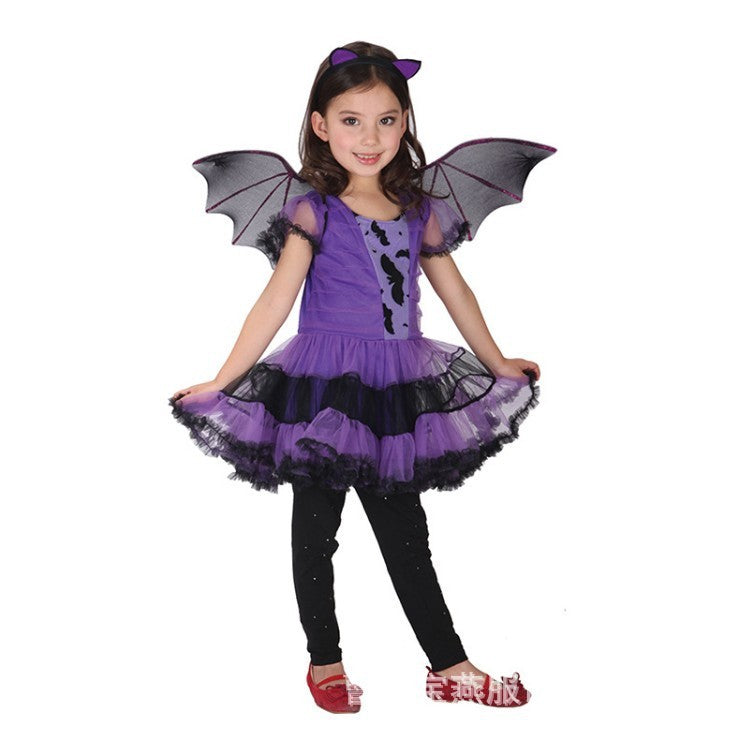 A young girl modeling a purple and black bat costume, featuring a tutu dress with bat wings, black leggings, and red shoes, set against a plain white background.