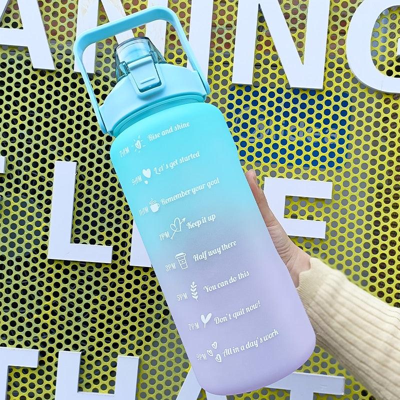Gradient water bottle with motivational text held by a hand against a yellow and black background