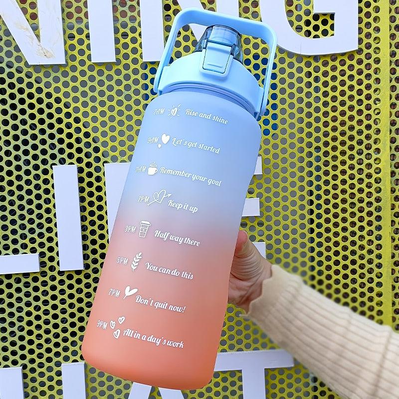 Gradient water bottle with motivational text held by a person against a yellow perforated background