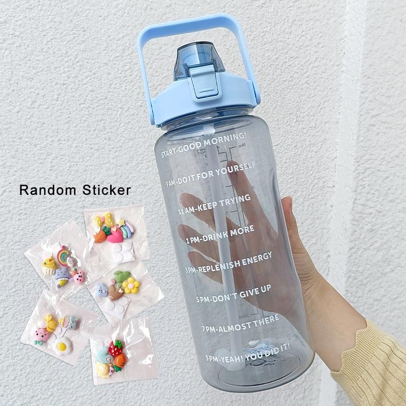 Clear water bottle with motivational text and a hand holding colorful stickers on a light gray background