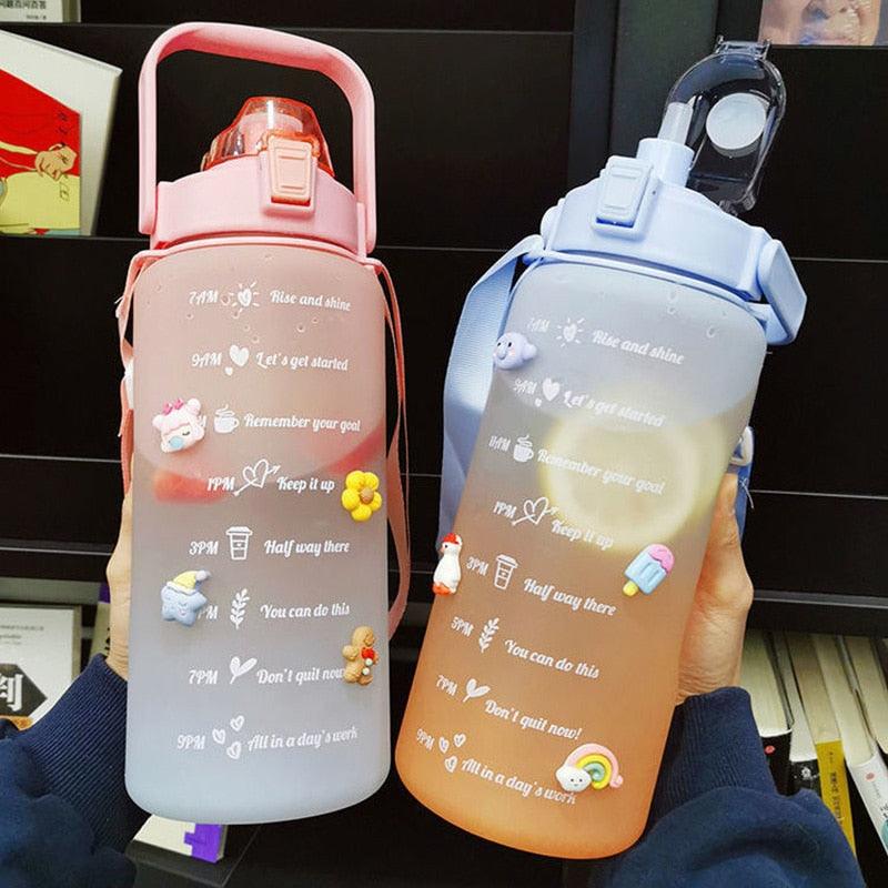 Two motivational water bottles held by a person with text and graphics on the containers.