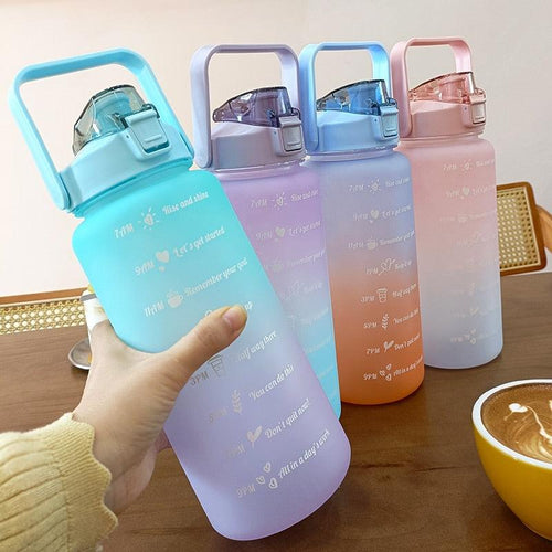 Set of colorful water bottles with handles on a wooden surface.