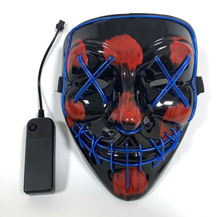 Black mask with red accents and blue LED lights next to a remote control on a white background