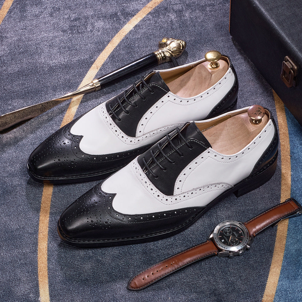 Black and white dress shoes with a watch on a textured surface