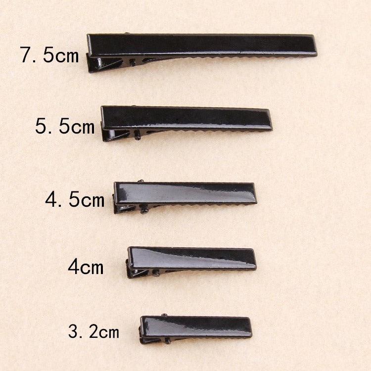 Set of black hair clips with measurements on a beige background