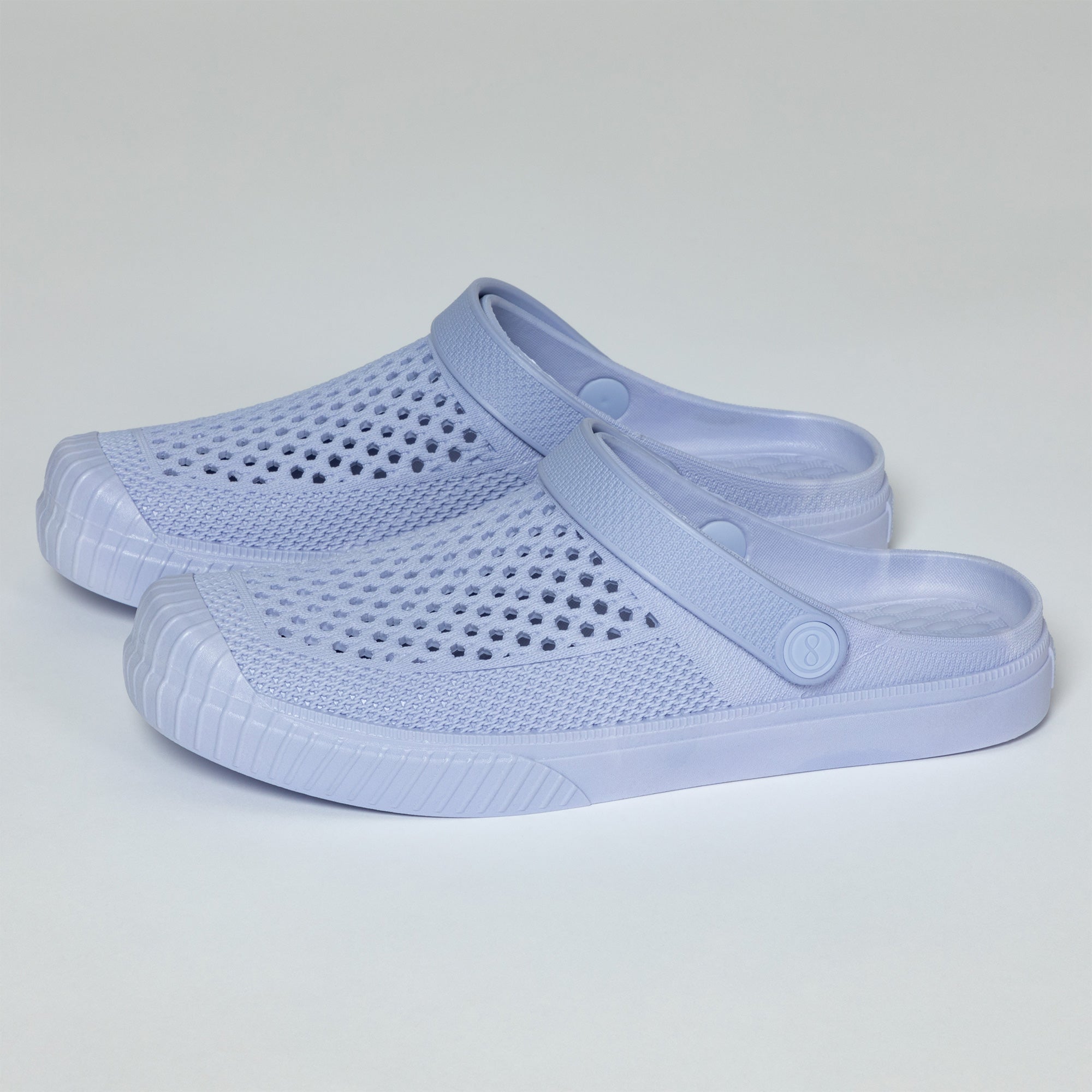 Pair of light blue clogs on a gray background