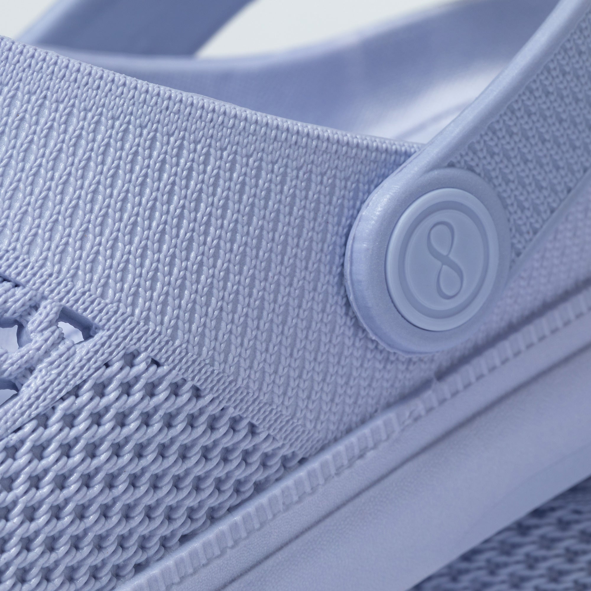 Close-up of a light blue shoe with a textured surface and a brand logo.
