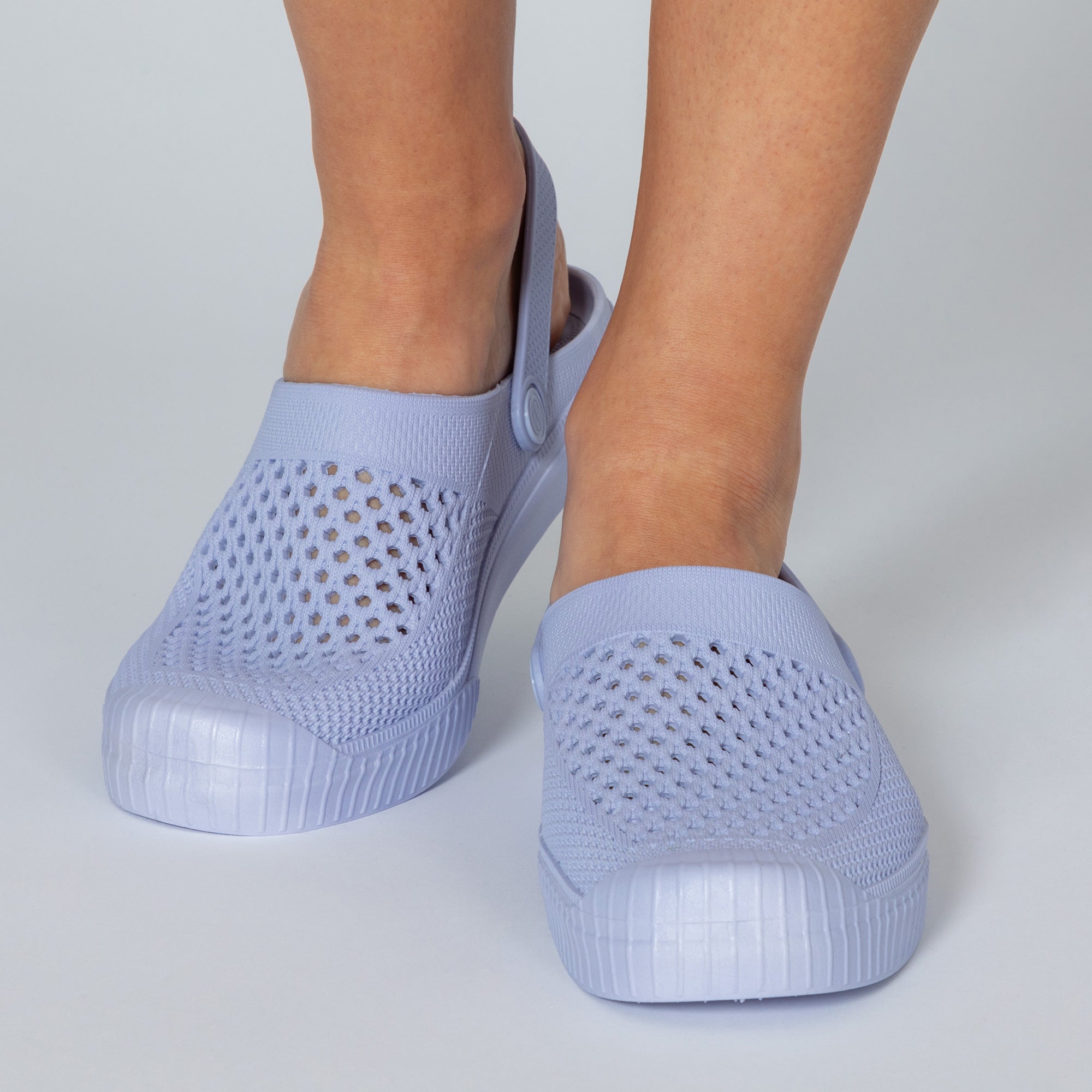 Light blue slip-on shoes with perforated design on a light gray background