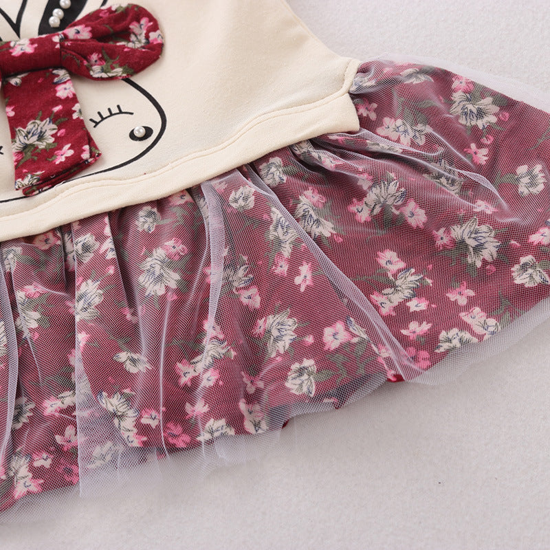 Close-up of a children's outfit with a floral skirt and headband on a light background
