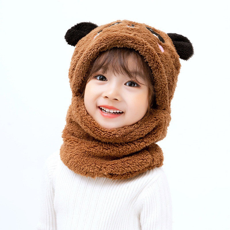 Child wearing a brown bear-themed hood and scarf on a white background