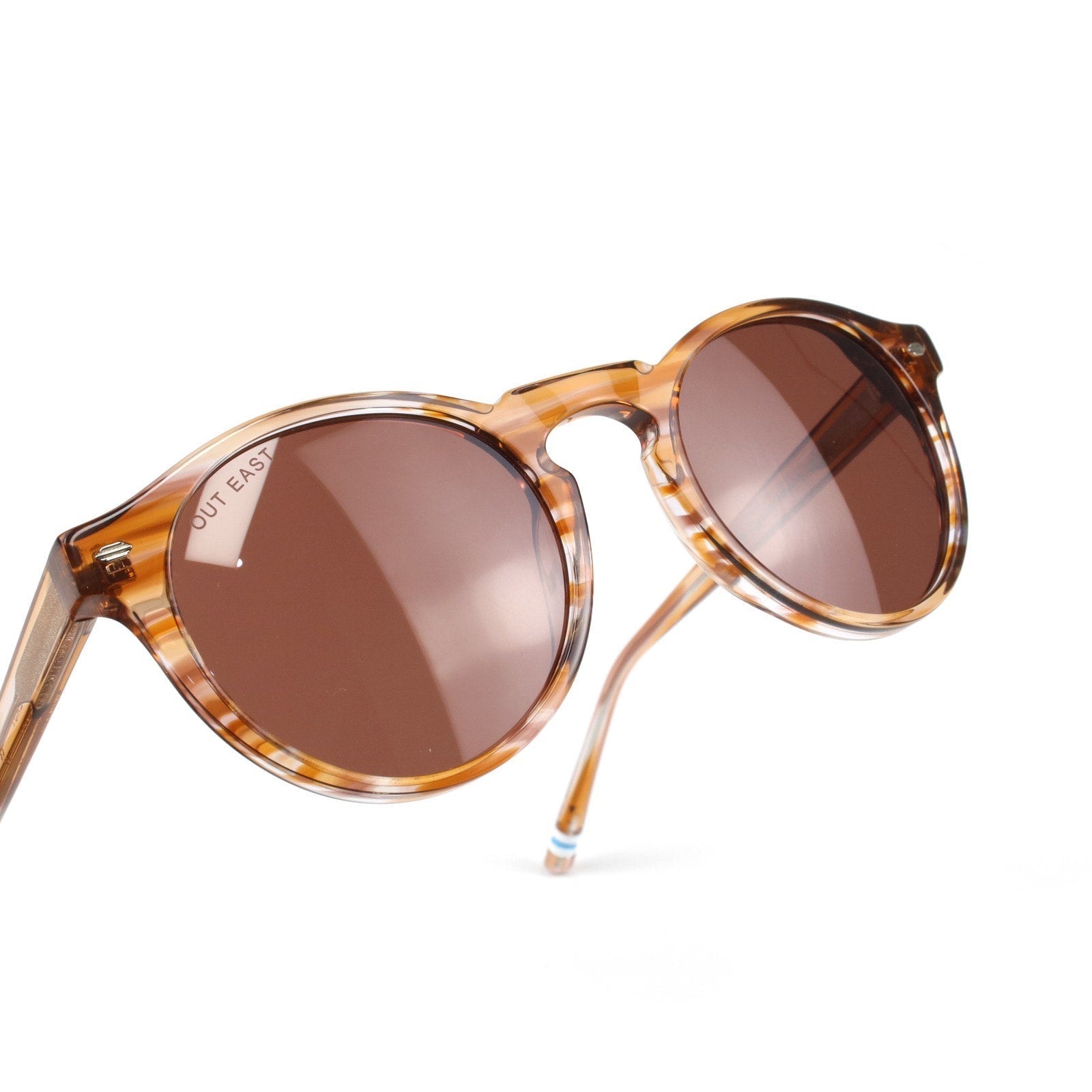 Sunglasses with tortoiseshell frame and brown lenses on a white background