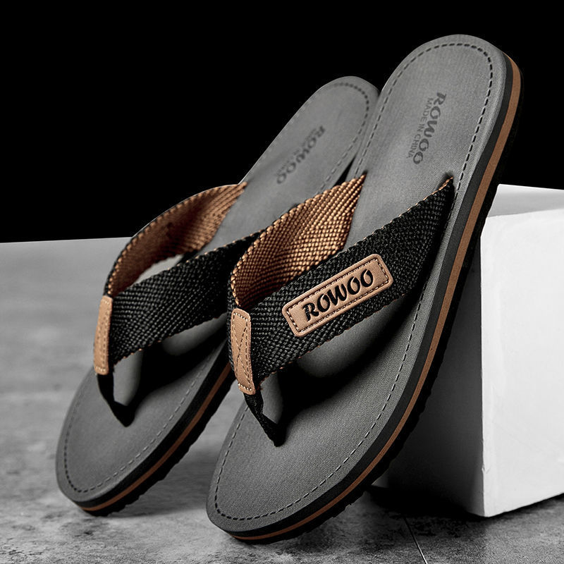 Pair of black and brown sandals with 'ROWOO' branding on a gray surface.